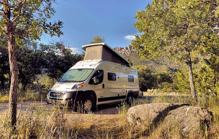 Solis parked in grass with pop top up